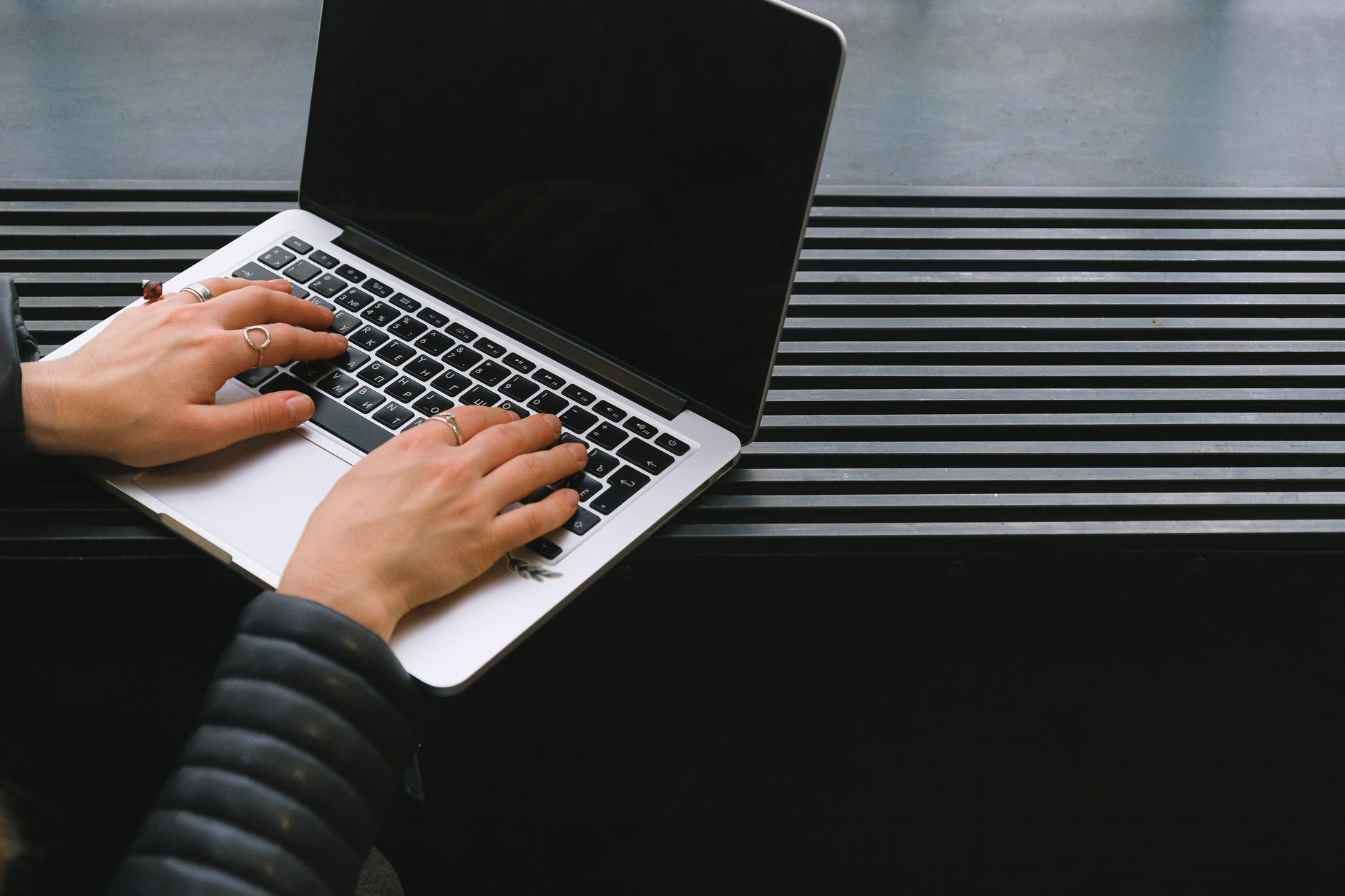 Gros plan sur des mains tapant sur un ordinateur portable élégant, idéal pour le travail indépendant.